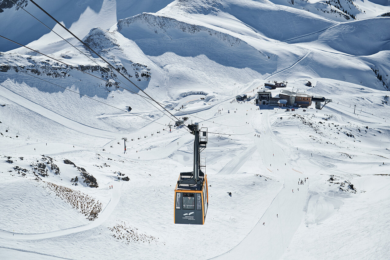 Seilbahn im Winter mit klar sichtbarer Werbefläche für ein Unternehmen. Werbeplakate an Seilbahnen bieten eine einzigartige Möglichkeit für Werbung auf Bergbahnen.