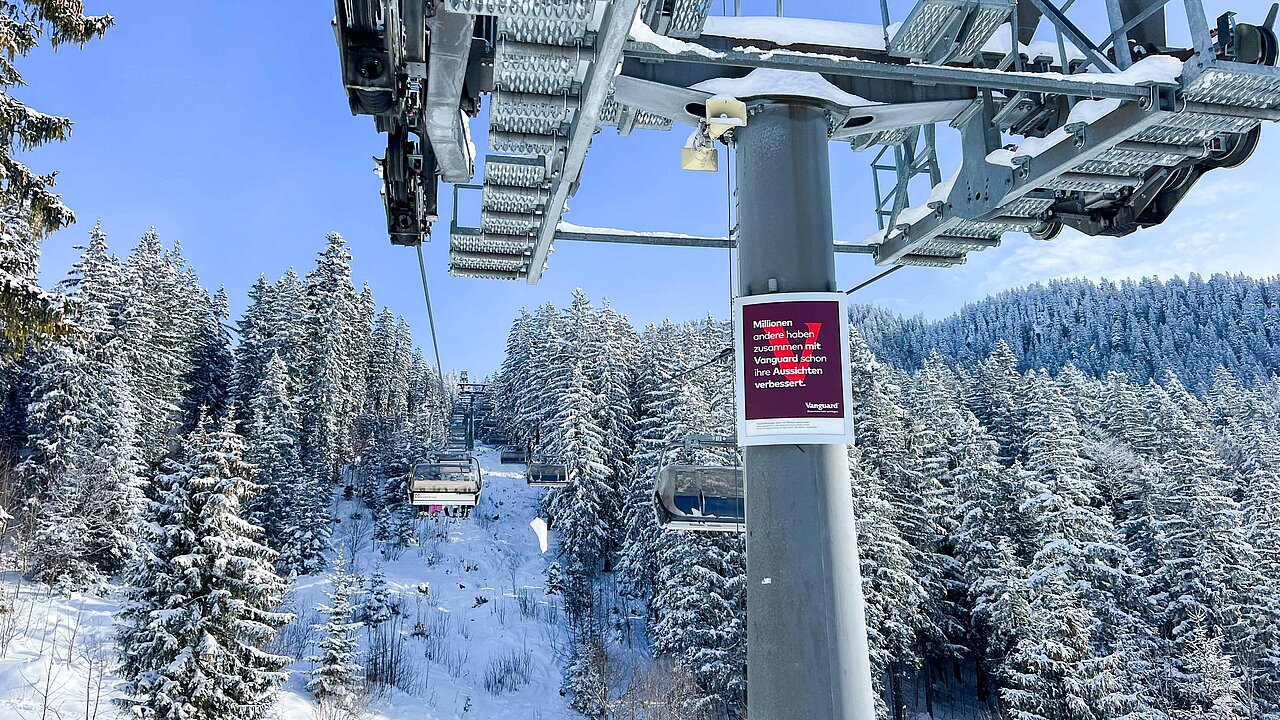 Liftstützen an einer Bergbahnstation im Schnee mit Werbung für Vanguard.