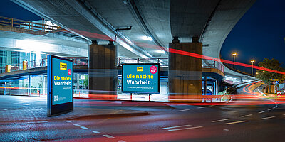 Klassisches Großplakat, daneben ein digitales Citylight. Plakatwerbung & digitale Außenwerbung - der perfekte Mix für maximale Sichtbarkeit. 