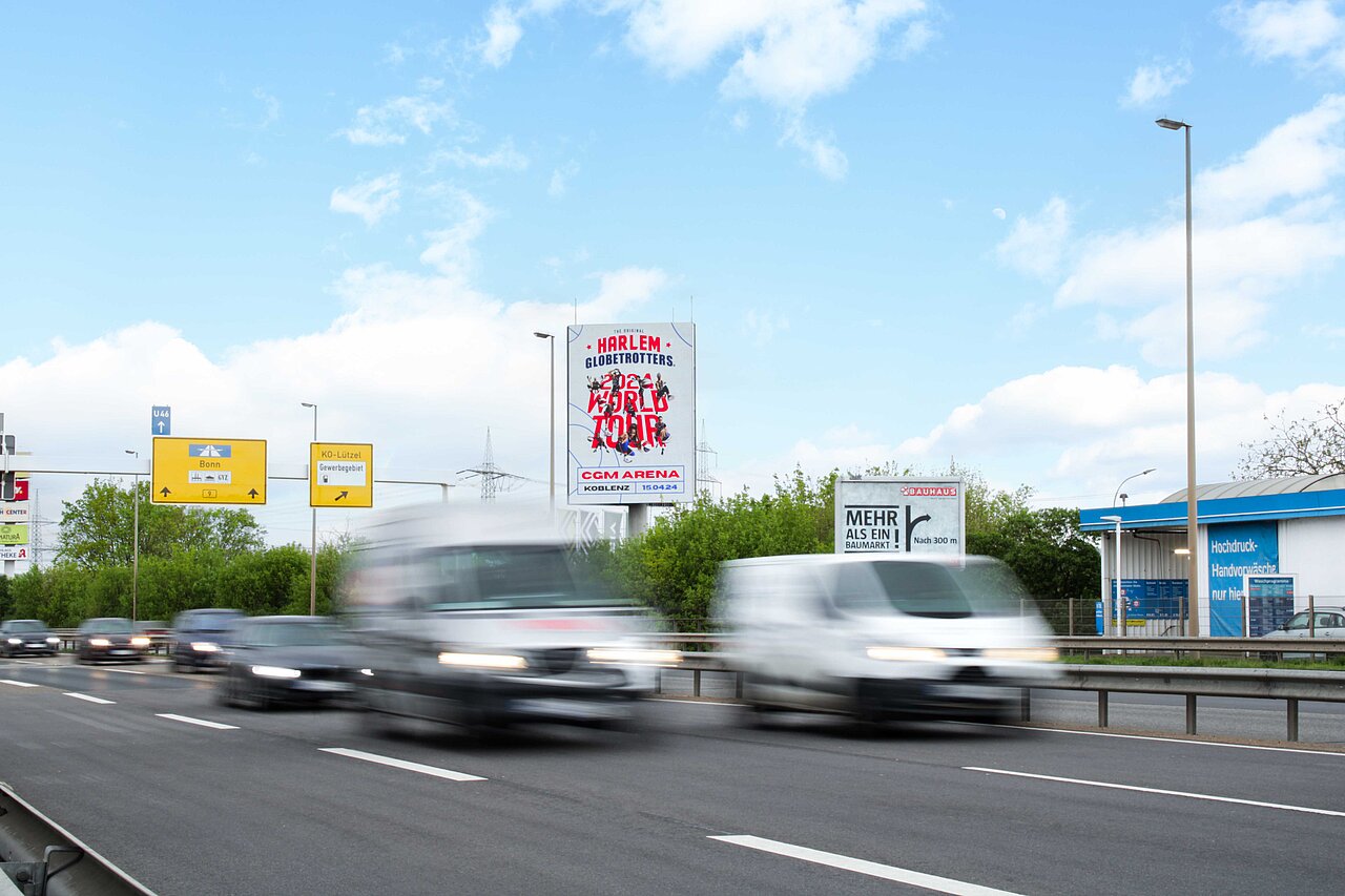 Digitaler Tower mit Werbung für die „Harlem Globetrotters World Tour“ an einer stark befahrenen Straße, ideal für aufmerksamkeitsstarke digitale Außenwerbung.