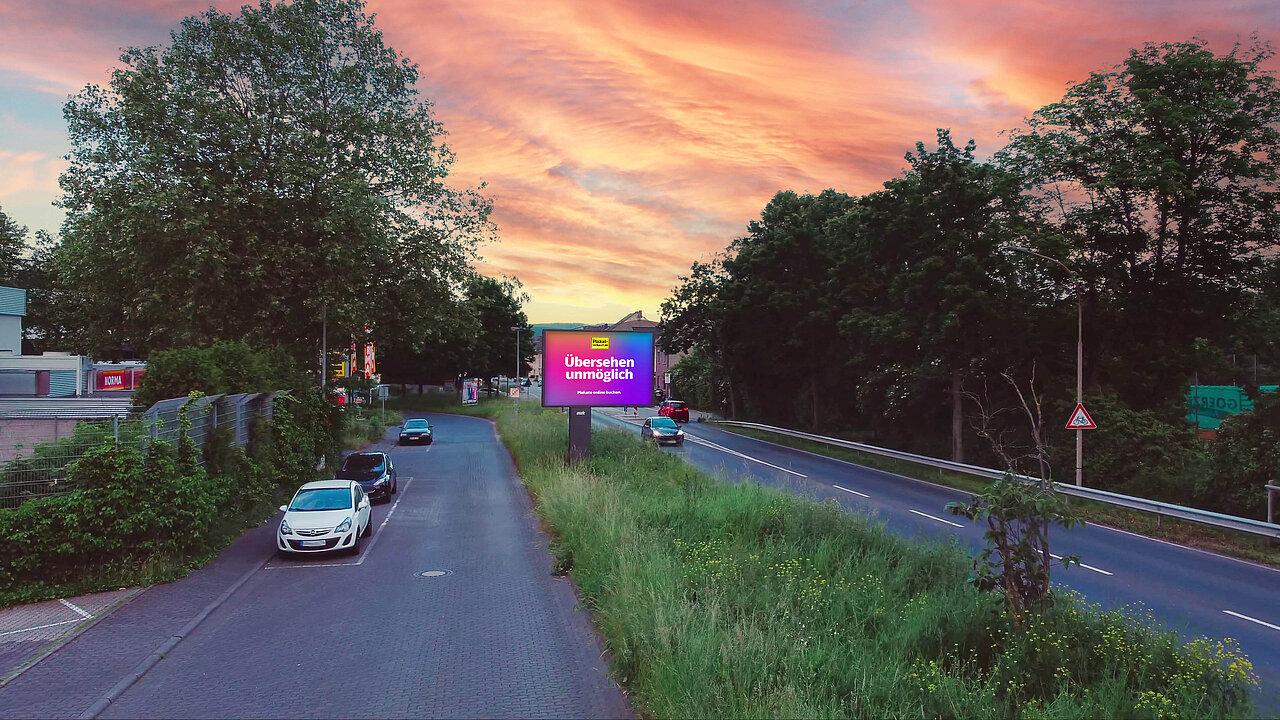Digitales Großplakat mit der Aufschrift „Übersehen unmöglich“ an einer Straße bei Sonnenuntergang, ideal für aufmerksamkeitsstarke digitale Außenwerbung.
