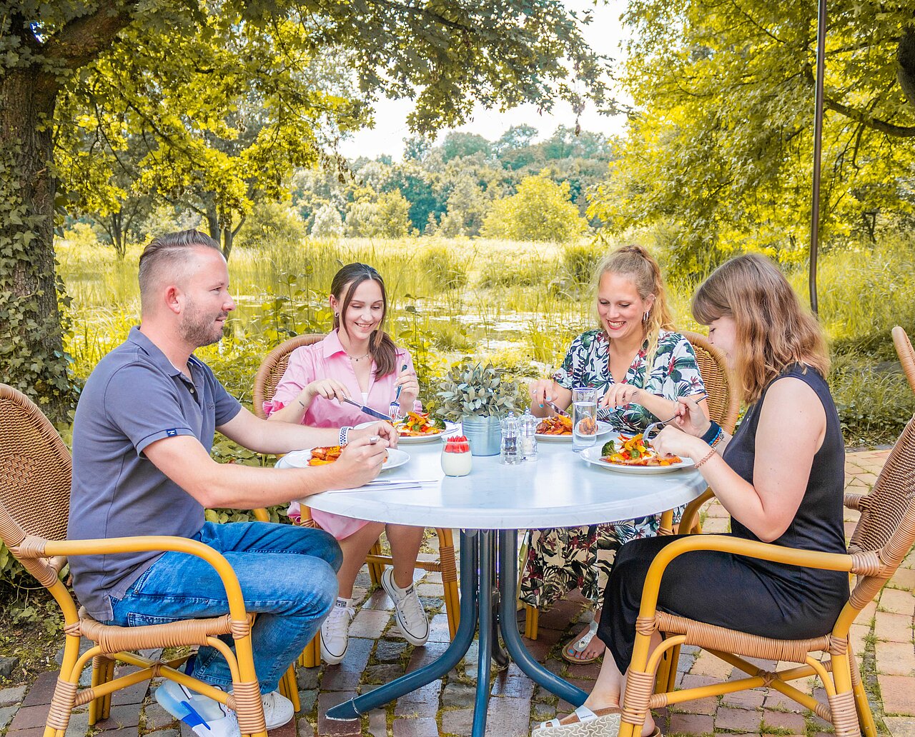 Team von Plakat-verkauft.de sitzt beim Mittagessen am Teich auf dem Firmengelände