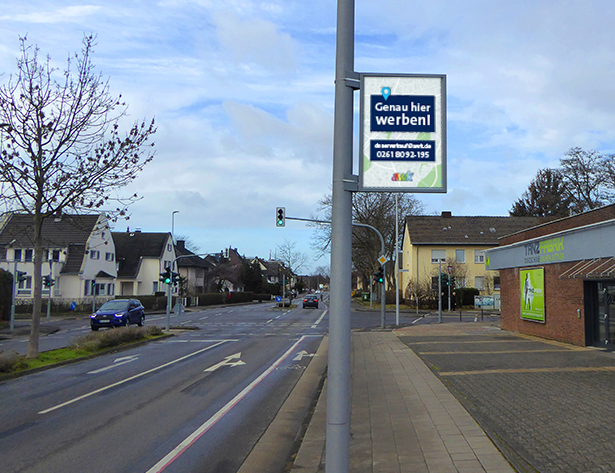 City Flag (Lichtmastenwerbung) mit der Aufschrift „Genau hier werben“ für langfristige Außenwerbung mit einer Mindestlaufzeit von 36 Monaten, ideal für ständige Sichtbarkeit.